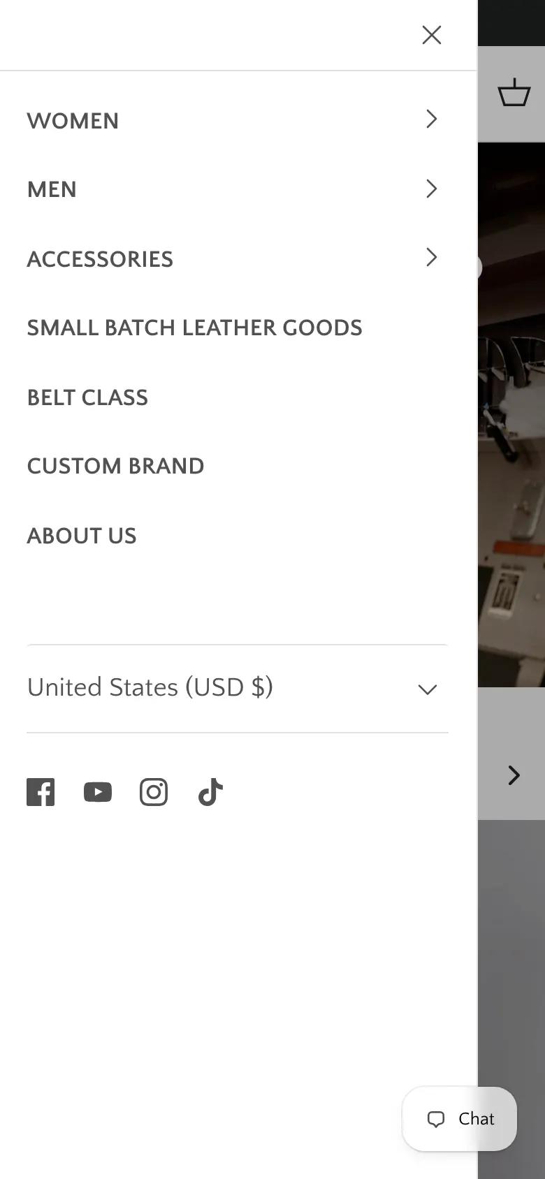 The Orox mobile menu open on a phone, listing Women, Men, Accessories, Small Batch Leather Goods, Belt Class, Custom Brand and About Us, with a currency selector and four social icons below and a large empty area beneath them.